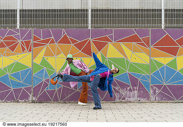 Couple dancing in front of colorful wall