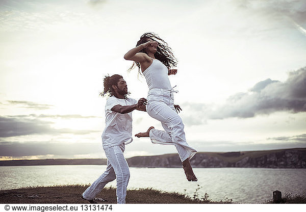Couple dancing on field against sky