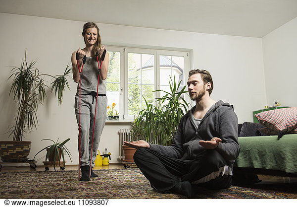 Couple doing exercise in living room  Munich  Bavaria  Germany