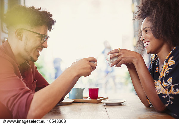 Couple drinking coffee face to face in cafe