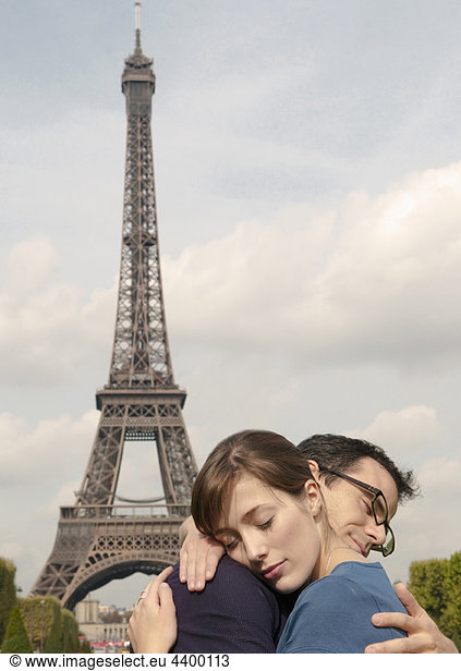 Couple embrace by Eiffel tower Paris