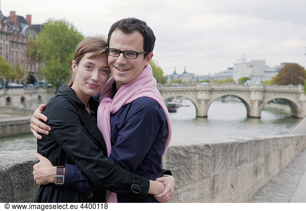 Couple embrace on banks of the Seine