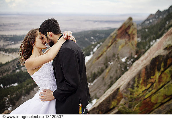 Couple embracing against mountains