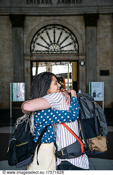 Couple embracing each other by train on railroad station platform