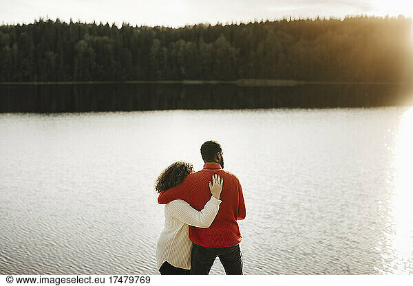 Couple embracing while looking at lake
