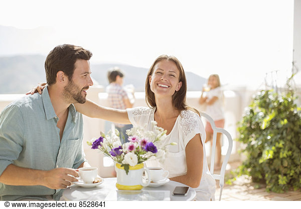 Couple enjoying coffee on balcony