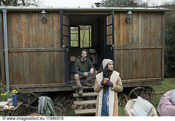 Couple enjoying coffee outside tiny cabin rental