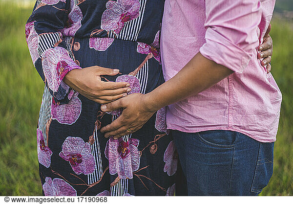 Couple expecting a baby. A man and a woman hold stomachs .