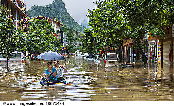 Couple Floating On A Raft During The Floods In Yangshuo