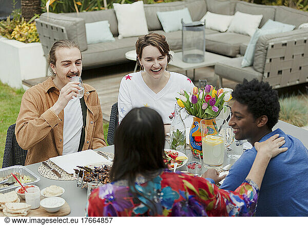 Couple friends talking and enjoying lunch at patio table