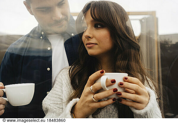 Couple holding coffee cups in dome tent