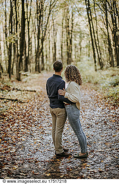 Couple holding each other on woodland path forest  Michigan