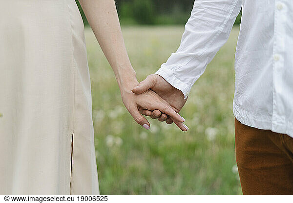 Couple holding hands on field