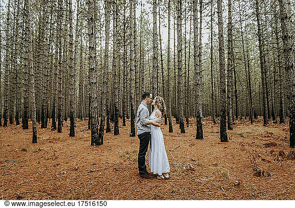 couple holds hugs intimate with each other in pine forest woodlands