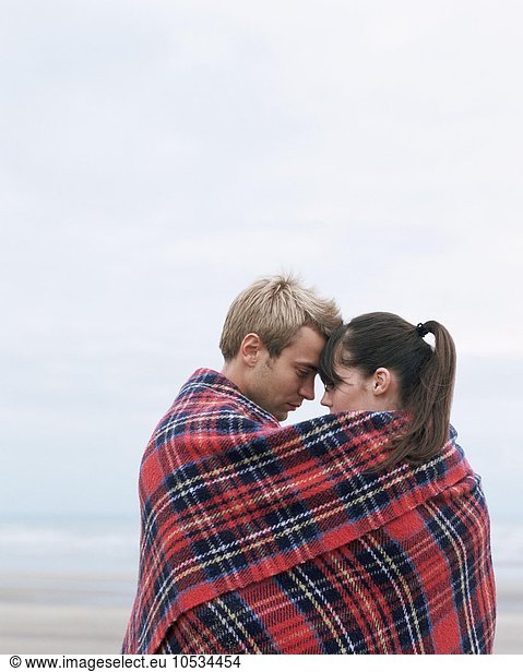 Couple hugging under blanket