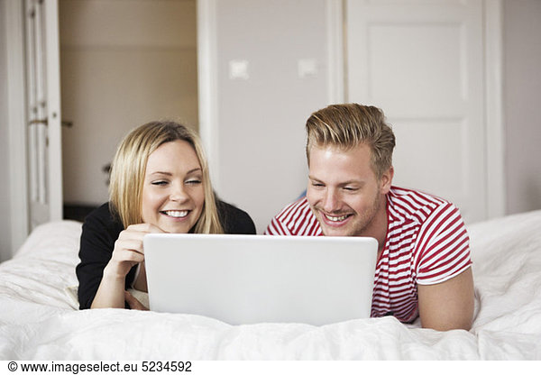 Couple in bed with laptop