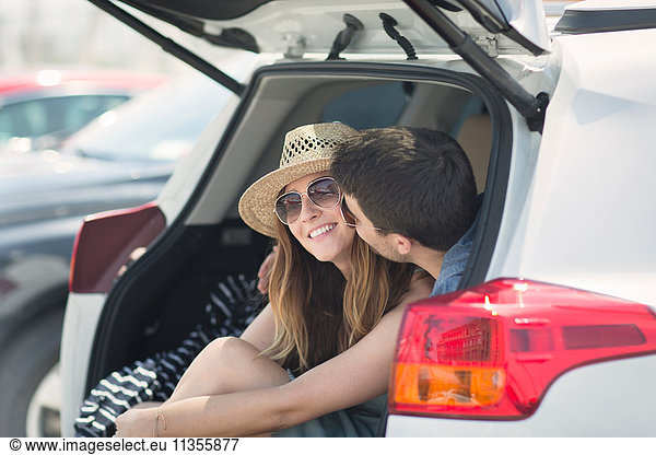 Couple in car boot kissing