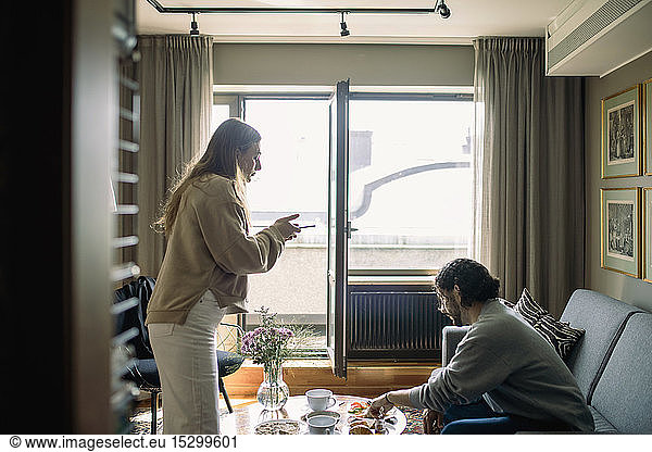 Couple in hotel room  woman taking photo of breakfast tray