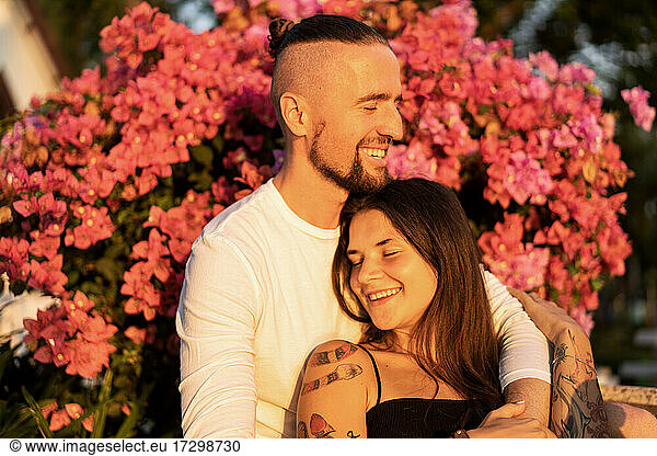 couple in love among flowers hugs and laughs