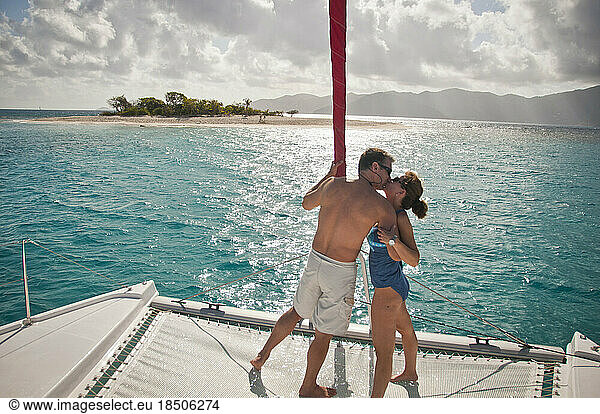Couple kissing on a sailboat.