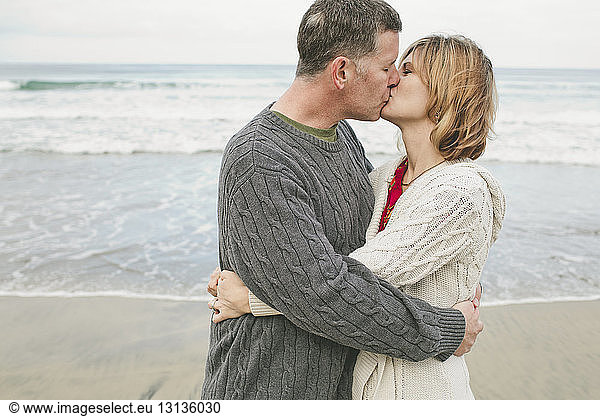 Couple kissing while embracing at beach