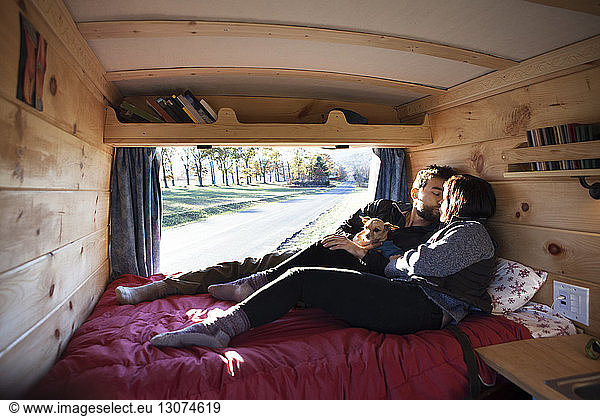 Couple kissing while relaxing in camper van