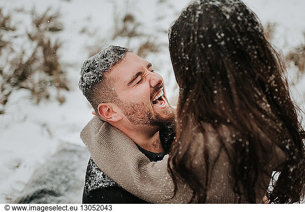 Couple laughing in snowy landscape