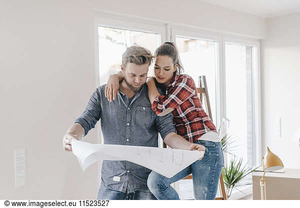 Couple looking at floor plan of theit new home