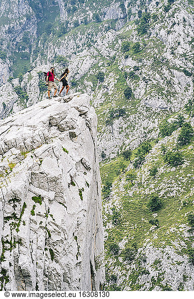 Couple looking at view while standing on mountain peak at Ruta Del Cares  Asturias  Spain