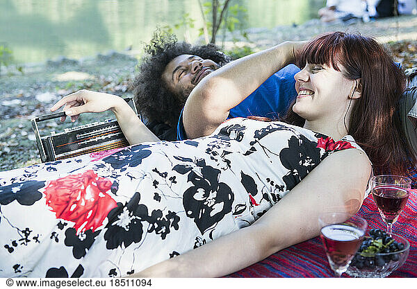 Couple lying on blanket at lakeshore in the English Garden  Munich  Germany