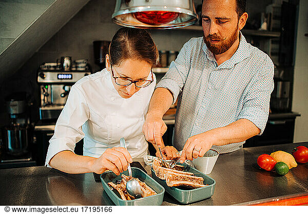 Couple of chefs working together while preparing food in restaurant