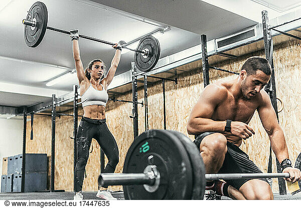 couple of man and woman doing weights in gym  crossfit