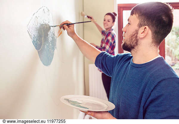 Couple painting wall mural
