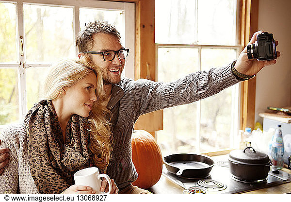 Couple photographing while sitting at home