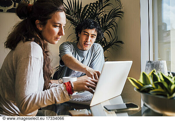 Couple planning while using laptop at home