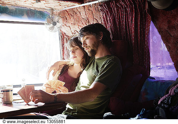 Couple playing cards while sitting in camper van