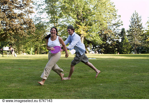 Couple Playing Frisbee in Park