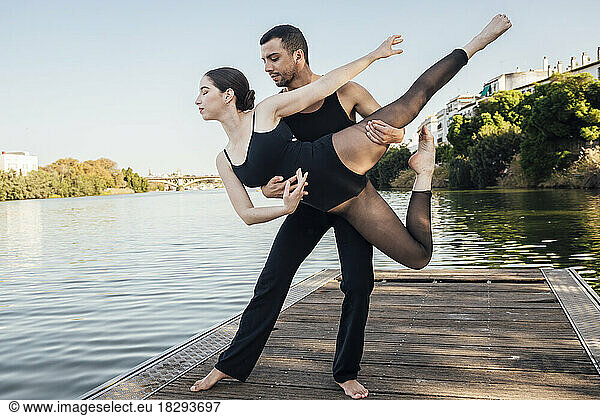Couple practicing ballet dance on wooden pier