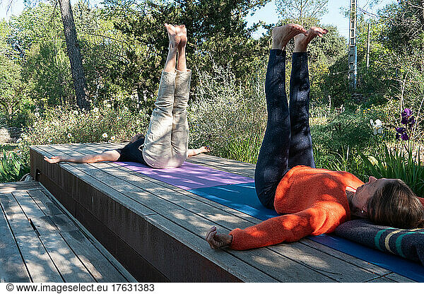 Couple practicing yoga outdoors.