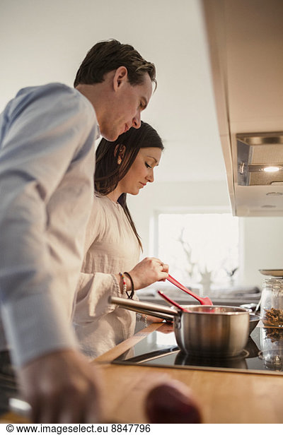 Couple preparing food in domestic kitchen