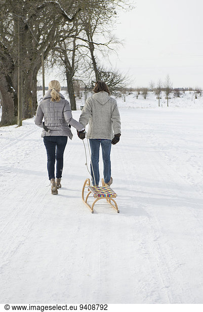 Couple pulling sledge in snow