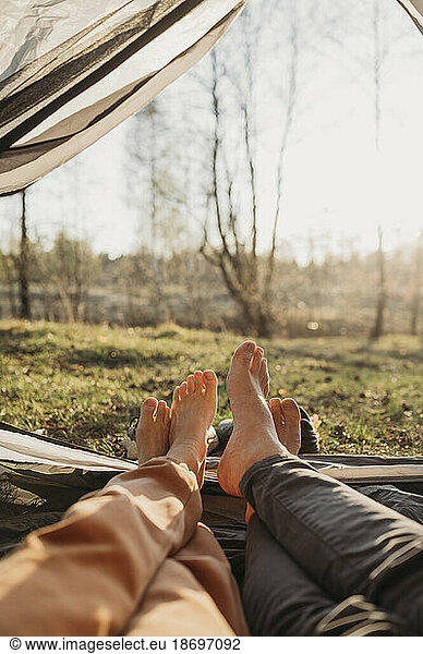 Couple relaxing in tent on sunny day