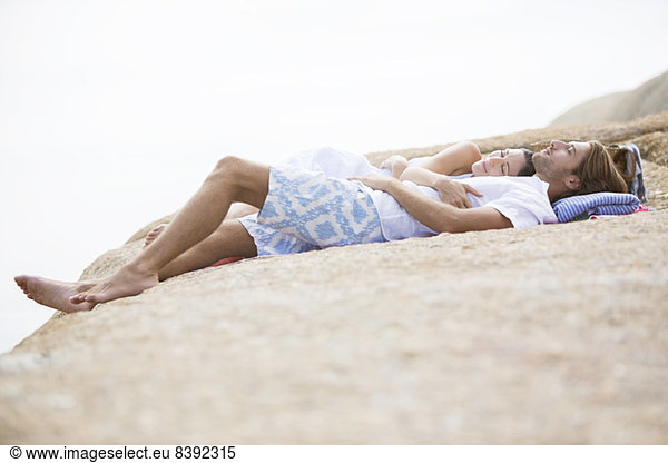 Couple relaxing on rock formation
