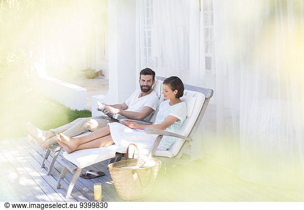 Couple relaxing together in lawn chairs outdoors