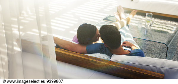 Couple relaxing together on sofa in modern living room