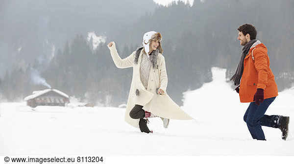Couple running in snowy field