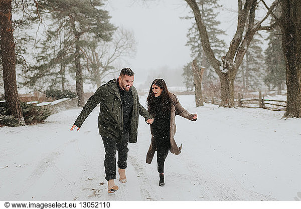 Couple running in snowy landscape  Georgetown  Canada