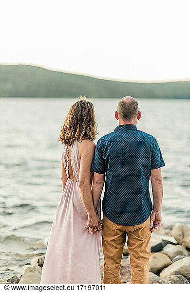 couple sharing a tender moment by the water during sunset together