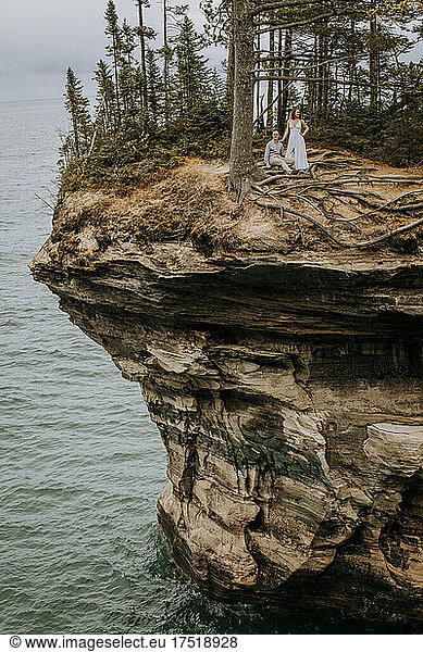 Couple sit among tree roots on cliff edge  Pictured Rocks  Michigan