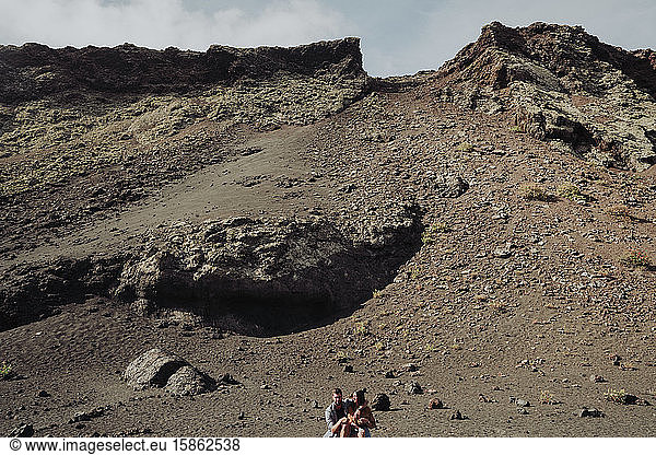 Couple sitting inside the Volcano Cuervo in Lanzarote  Timanfaya.